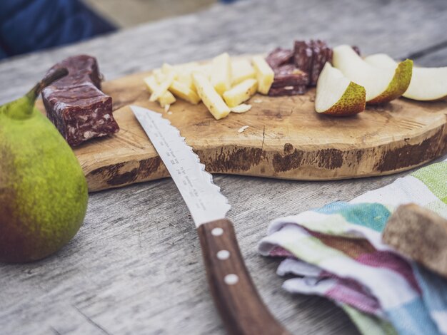 Auf einem Holzbrett sind Wurst, Käse und Obstscheiben aufgeschnitten als Stärkung auf der Wanderung. | © Davos Klosters Mountains