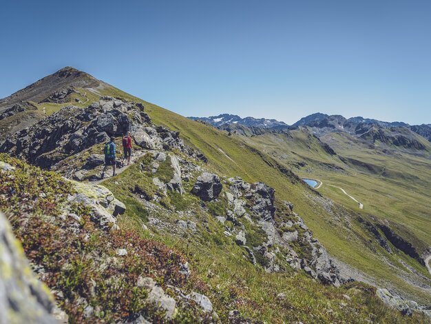 Zwei Wanderer geniessen die Gratwanderung vom Jakobshorn zum Jatzhorn mit dem Stadlersee im Blick.  | © Davos Klosters Mountains