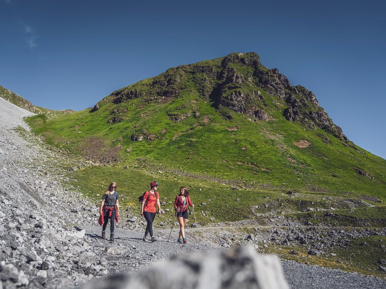 Drei Freunden haben Spass bei der Wanderung auf dem Felsenweg auf Parsenn.  | © Davos Klosters Mountains