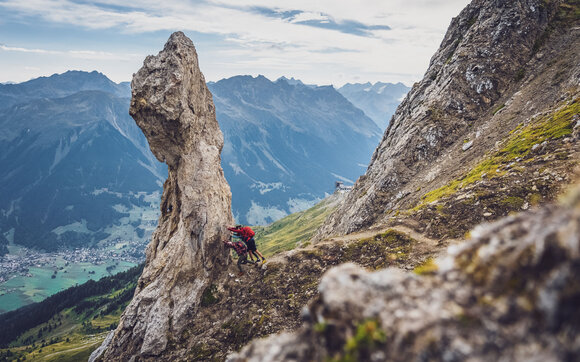 Drei Wanderer versuchen aus Spass den Fels mit dem Namen Casannamändli umzustossen.  | © Davos Klosters Mountains