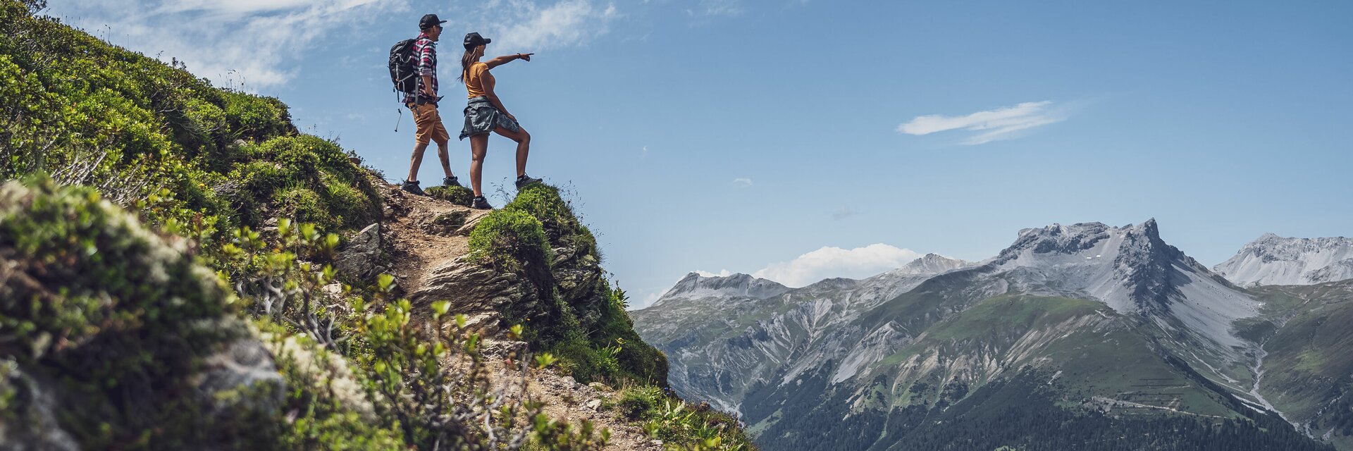 Man and woman standing on a rock, looking into the horizon | © Davos Klosters Mountains Man and woman standing on a rock, looking into the horizon | © Davos Klosters Mountains