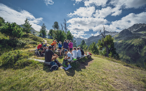 Eine Schulklasse geniesst das Grillieren an der Feuerstelle beim Bäbiwald. | © Davos Klosters Mountains