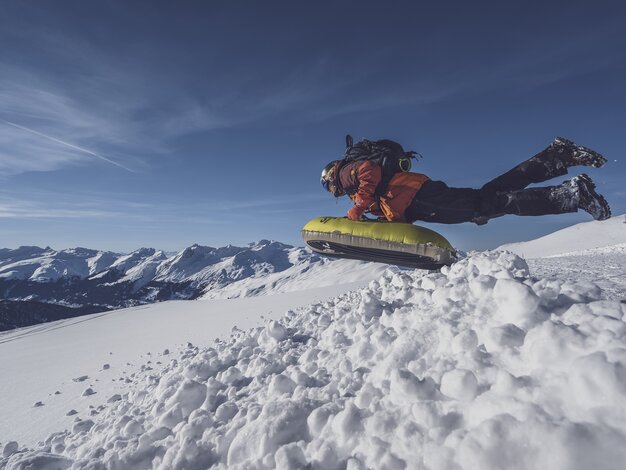 Mit einem Sprung startet ein Gast die Abfahrt über die verschneiten Hänge auf Pischa. | © Davos Klosters Mountains