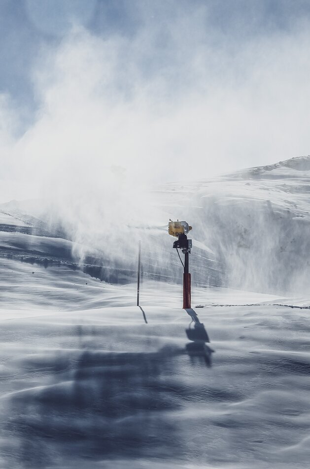 Ein Schneeerzeuger produziert eine Menge Schnee, der sich langsam zu Boden senkt. | © Davos Klosters Mountains