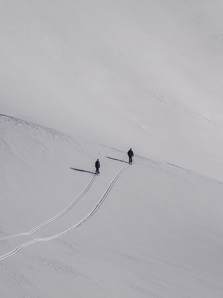 Zwei Skifahrer hinterlassen Spuren im tiefen Schnee. | © Davos Klosters Mountains