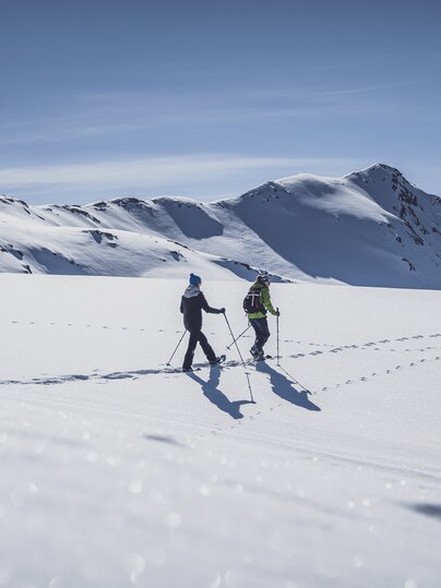 Zwei Frauen laufen mit den Schneeschuhen durch den tiefen Schnee. | © Davos Klosters Mountains