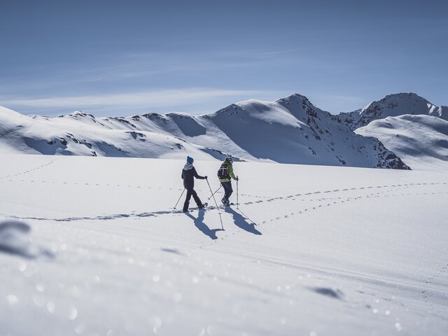 Zwei Frauen laufen mit den Schneeschuhen durch den tiefen Schnee. | © Davos Klosters Mountains