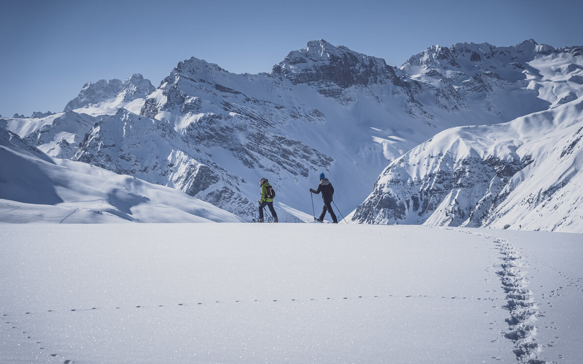 Seitlicher Blick auf zwei Schneeschuhläufer die auf dem Jakobshorn über den unberührten Schnee gehen. | © Davos Klosters Mountains
