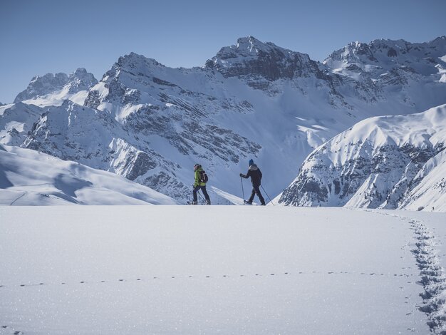 Seitlicher Blick auf zwei Schneeschuhläufer die auf dem Jakobshorn über den unberührten Schnee gehen. | © Davos Klosters Mountains