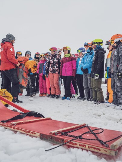 Gruppe Gäste wird vom Pisten und Rettungsdienst direkt auf der Skipiste instruiert  | © Davos Klosters Mountains 