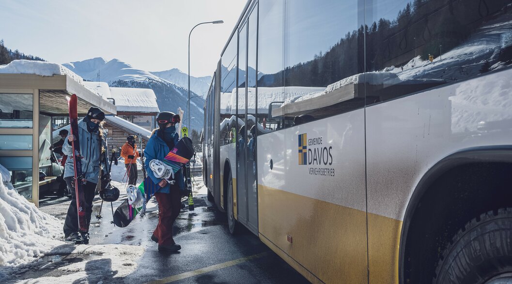 2 Skifahrer warten auf den Bus | © Davos Klosters Mountains 2 Skifahrer warten auf den Bus | © Davos Klosters Mountains