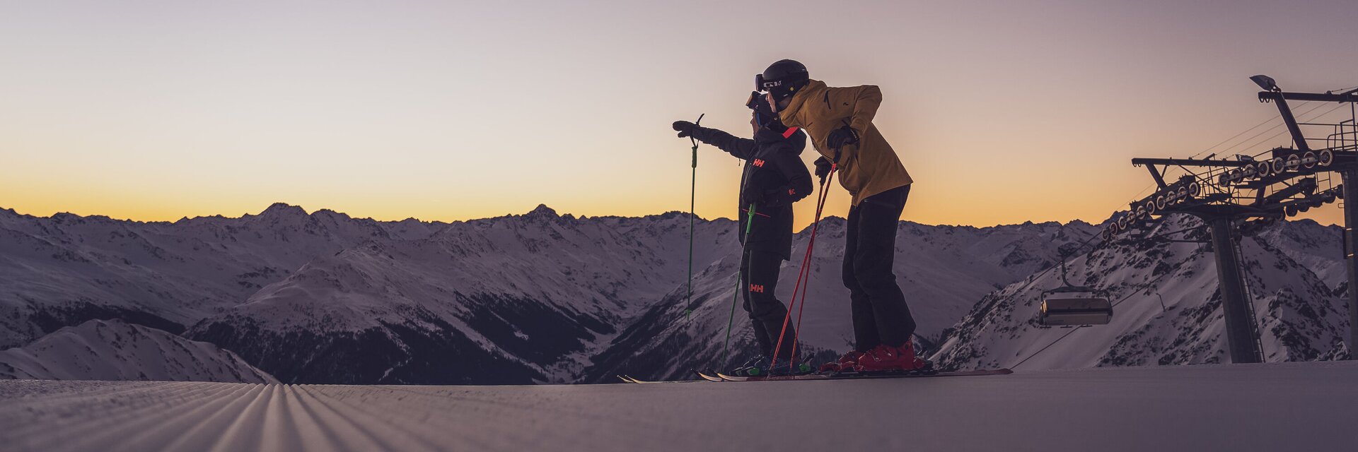 Zwei Skifahrer beim Sonnenaufgang, schauen in die Ferne | © Davos Klosters Mountains