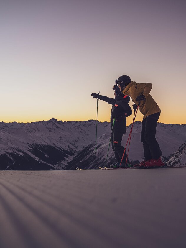 Two skiers at sunrise, looking into the distance | © Davos Klosters Mountains