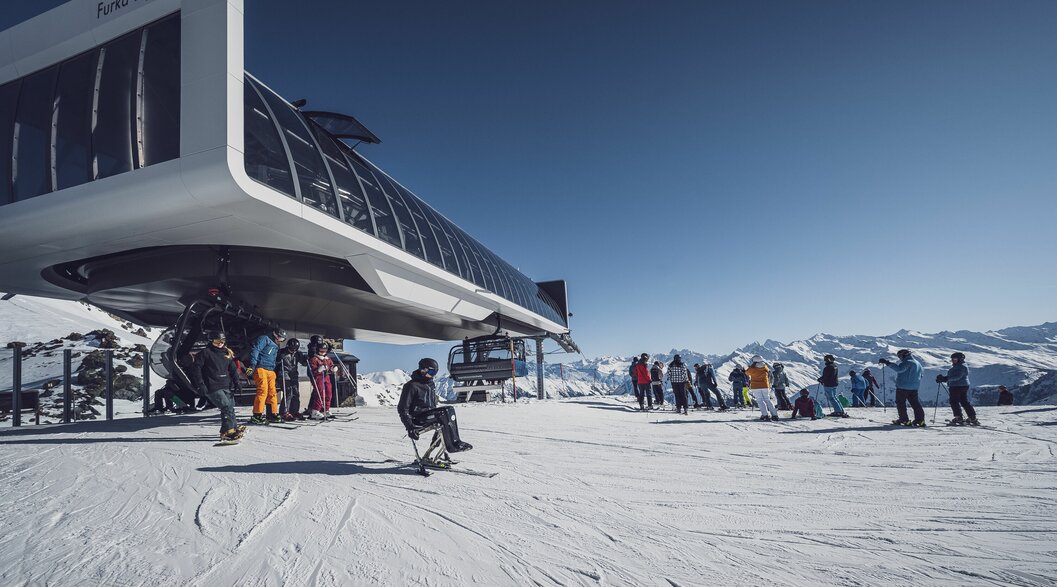 Gruppe Skifahrer und ein Monoskifahrer an der Talstation beim Sessellift | © Davos Klosters Mountains Gruppe Skifahrer und ein Monoskifahrer an der Talstation beim Sessellift | © Davos Klosters Mountains