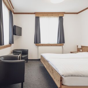 Hotel room with double bed and armchairs | © Davos Klosters Mountains