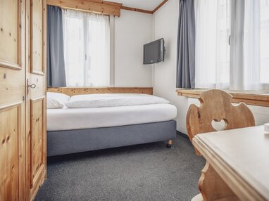 Helles Einzelzimmer mit Schreibtisch | © Davos Klosters Mountains