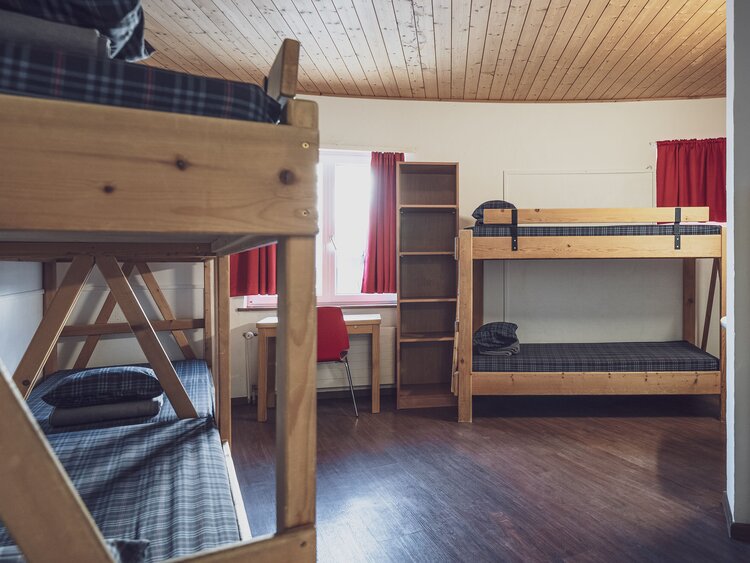 Mehrbettzimmer mit Stockbetten und Kleiderablagen  | © Davos Klosters Mountains 