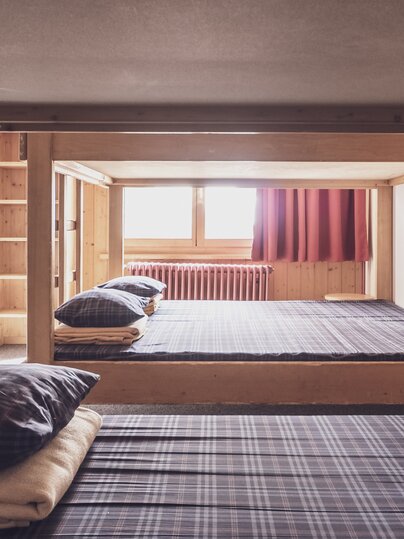 Mehrbettzimmer mit Doppelstockbetten und Kleiderablagen  | © Davos Klosters Mountains 