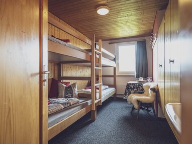 Mehrbettzimmer mit Stockbetten, Waschbecken, Tisch und Stuhl  | © Davos Klosters Mountains 