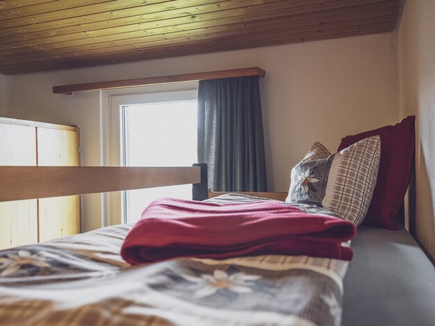 Stockbett mit Decke und einem Fenster | © Davos Klosters Mountains