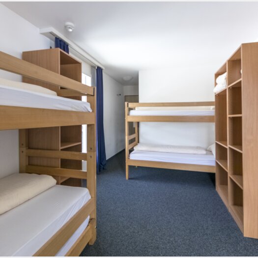 Mehrbettzimmer mit Stockbetten und Kleiderablagen | © Davos Klosters Mountains 