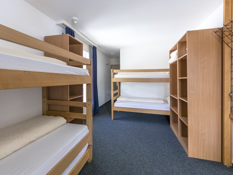 Mehrbettzimmer mit Stockbetten und Kleiderablagen | © Davos Klosters Mountains 