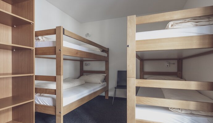 Einfaches Zimmer mit 2 Stockbetten und Kleiderablage  | © Davos Klosters Mountains 