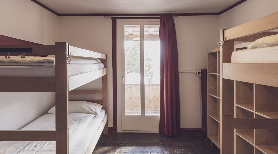 Mehrbettzimmer mit Stockbetten und Kleiderablagen | © Davos Klosters Mountains 