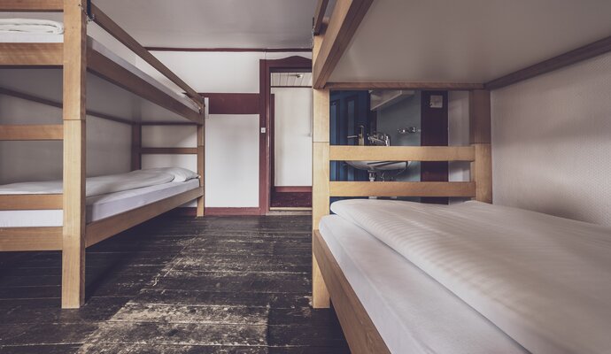 Mehrbettzimmer mit Stockbetten und Waschbecken  | © Davos Klosters Mountains 
