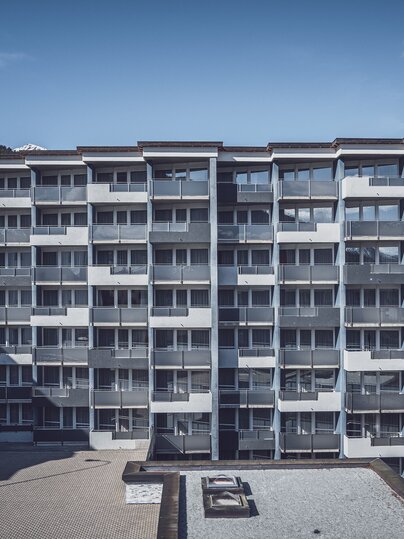 Mehrstöckiges Gebäude mit blauer Fassade und Balkonen | © Davos Klosters Mountains 