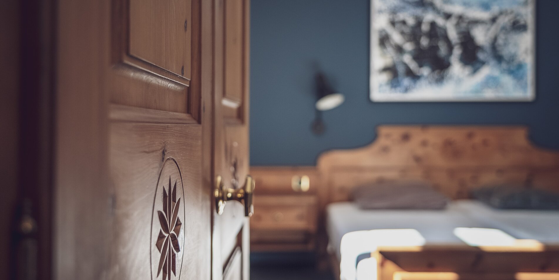 Zimmer mit Doppelbett, Bettwäsche und Nachttischlampe | © Davos Klosters Mountains 