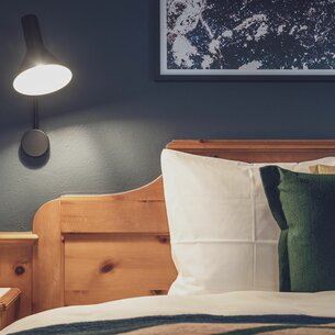 Hotelbett mit Bettlampe | © Davos Klosters Mountains