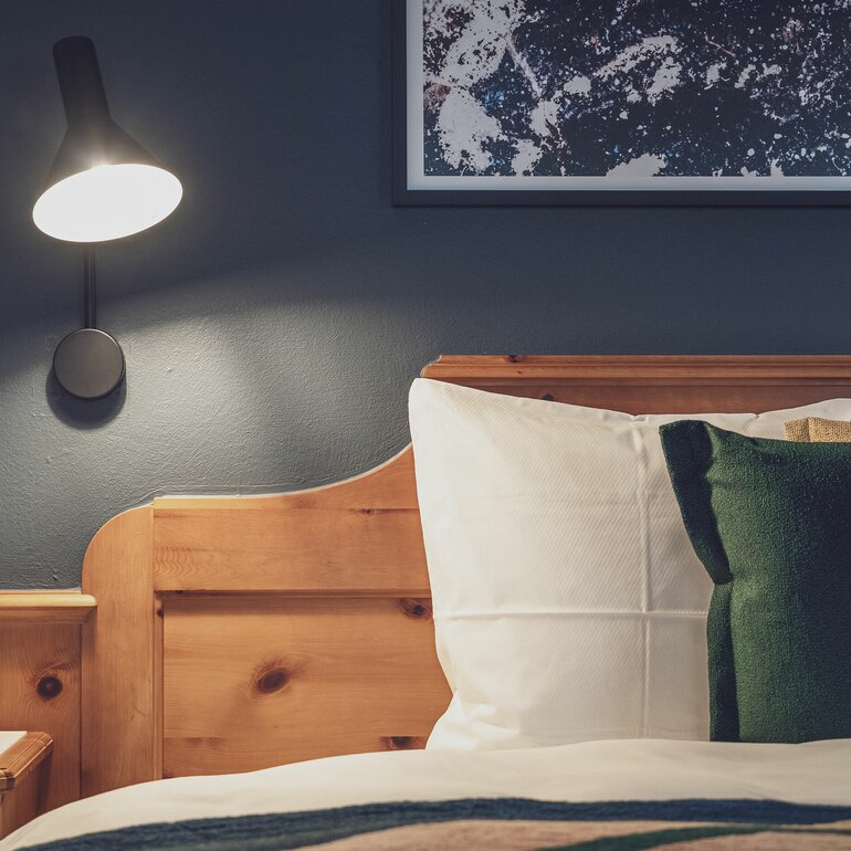 Hotelbett mit Bettlampe | © Davos Klosters Mountains