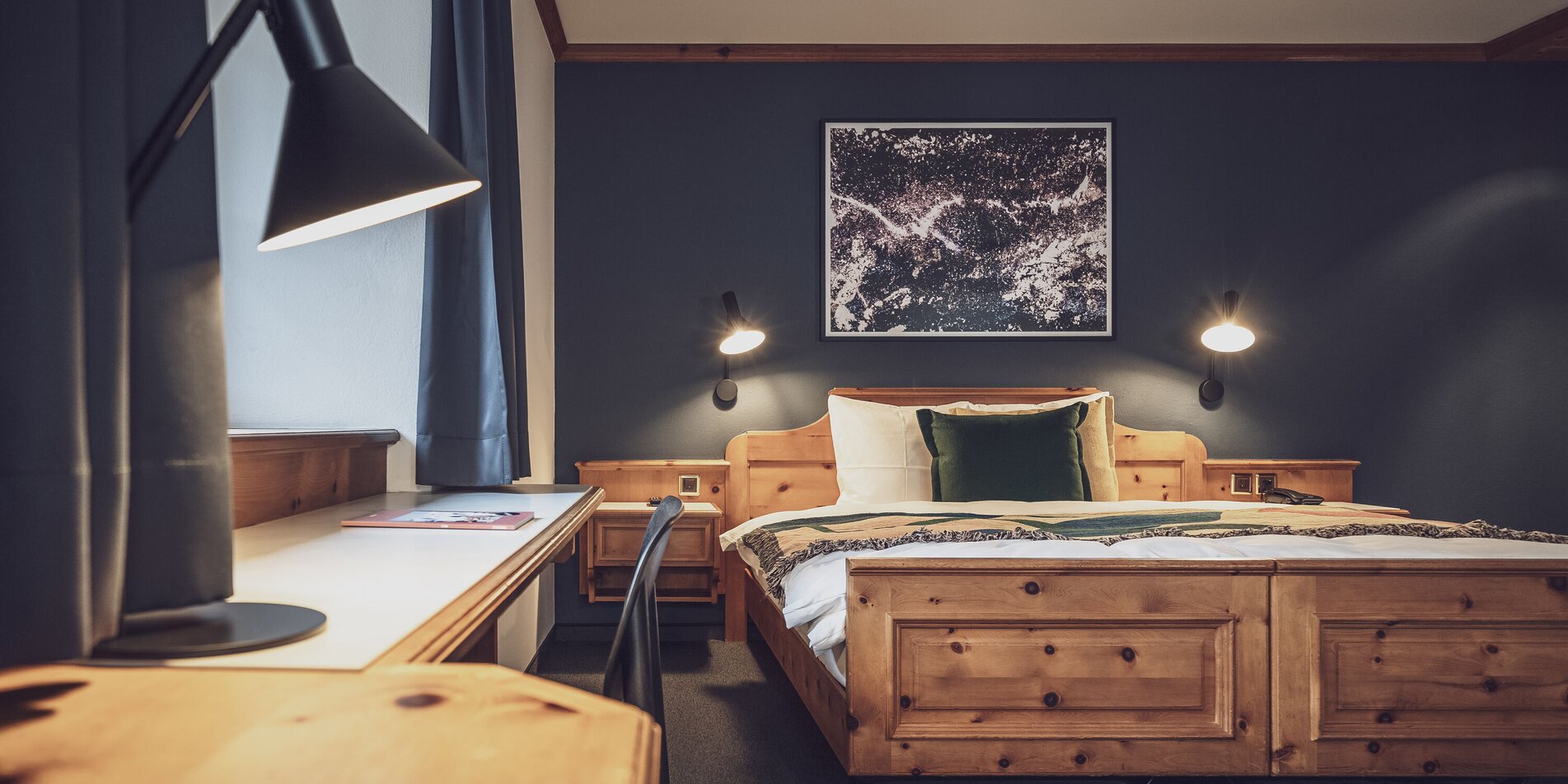 Doppelbettzimmer mit Bettwäsche und Nachttischlampe | © Davos Klosters Mountains 
