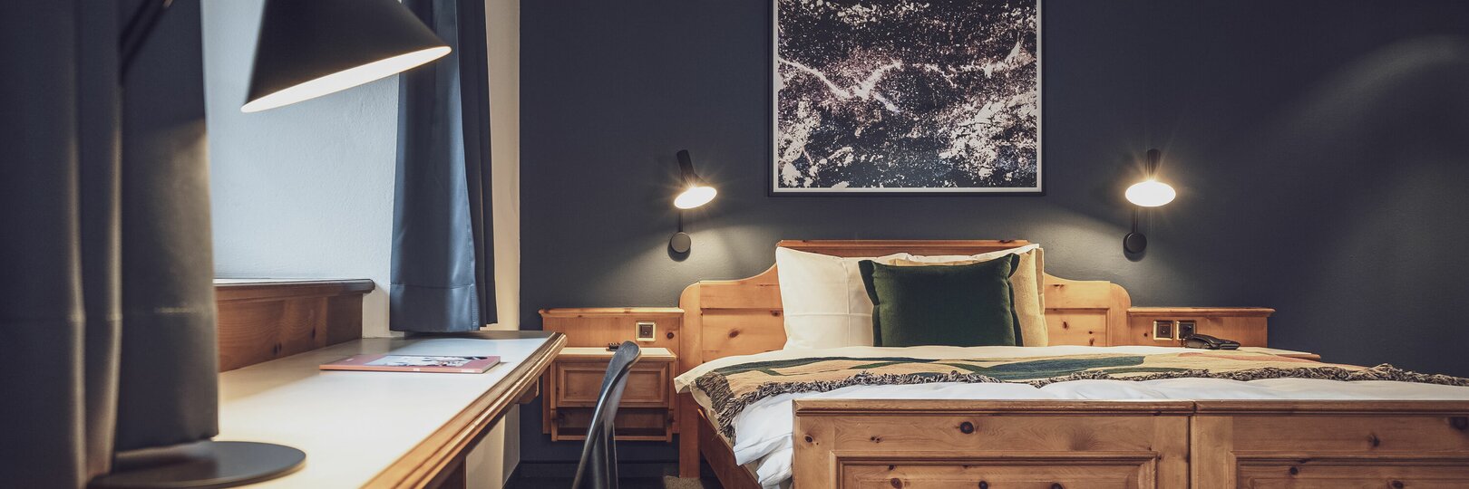 Double bed room with bed linen and night lamp | © Davos Klosters Mountains 