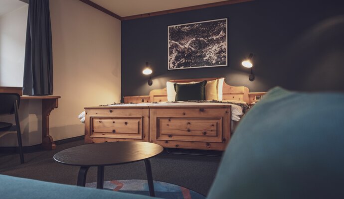 Double bed room with bed linen and salon table | © Davos Klosters Mountains 