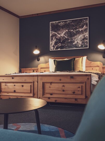 Doppelbettzimmer mit Bettwäsche und Salontisch | © Davos Klosters Mountains 