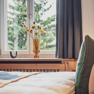 Hotelbett mit Sicht aus dem Fenster | © Davos Klosters Mountains