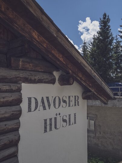 Aussenansicht eines Chalet mit Tannen im Hintergrund | © Davos Klosters Mountains 