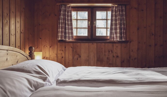 Doppelbett mit kleine Fenster | © Davos Klosters Mountains