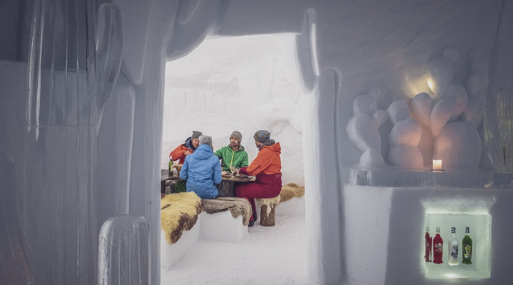 Schnee Iglu mit mehreren Personen sitzend auf Lammfell, am Fondueessen | © Davos Klosters Mountains Schnee Iglu mit mehreren Personen sitzend auf Lammfell, am Fondueessen | © Davos Klosters Mountains