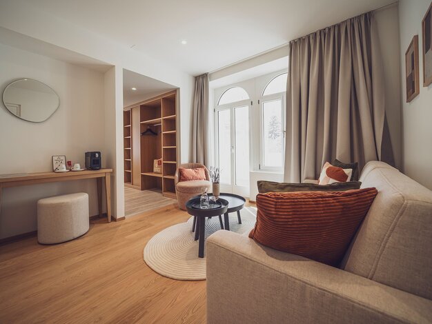 Helles Zimmer mit Garderobe, Salontisch und Couch | © Davos Klosters Mountains 