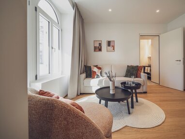 Helles Zimmer mit Holzboden, Salontisch und Sitzgelegenheiten | © Davos Klosters Mountains 