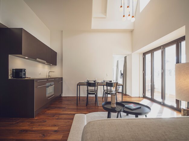 Helles Apartment mit Holzboden, Einbauküche, Esstisch und Couch | © Davos Klosters Mountains 