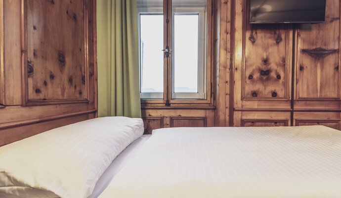 Hotelbett mit Holzvertäfelung | © Davos Klosters Mountains