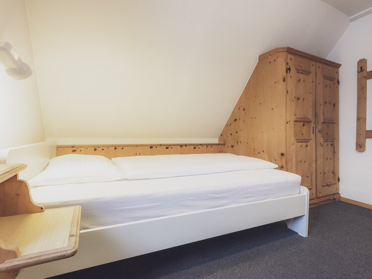 Hotelbett mit Nachttisch | © Davos Klosters Mountains