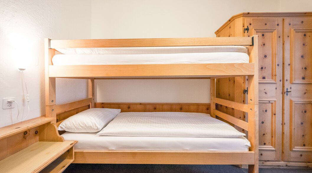 Hotel room with bunk beds and wardrobe | © Davos Klosters Mountains