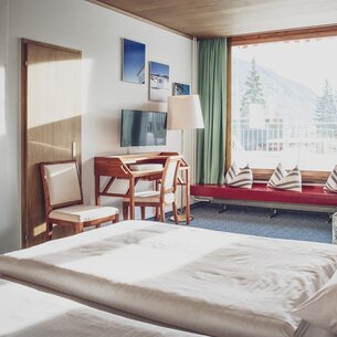 Bright family hotel room with desk | © Davos Klosters Mountains