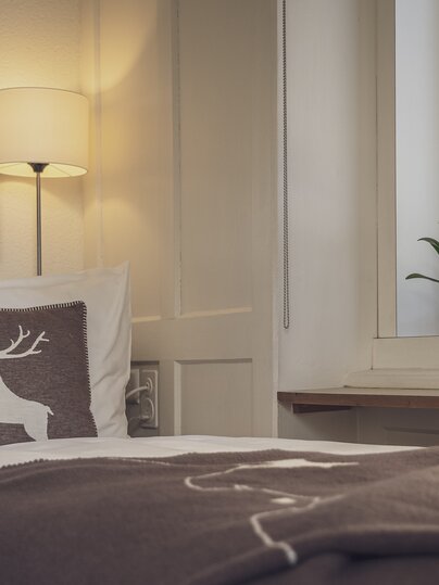 Bett mit brauner Tagesdecke | © Davos Klosters Mountains