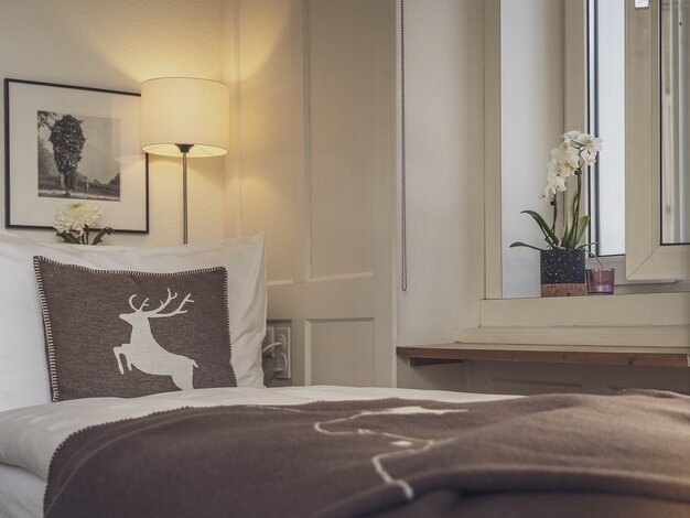Bett mit brauner Tagesdecke | © Davos Klosters Mountains